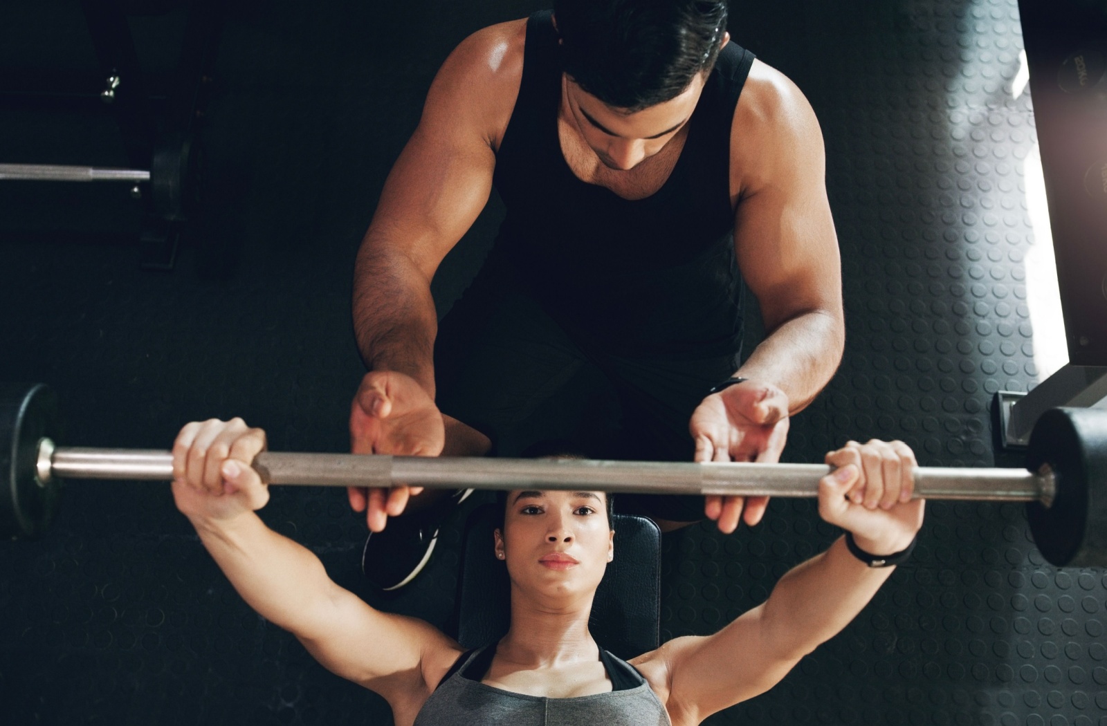 A personal trainer in Halifax guiding a client through a strength training session to build muscle.